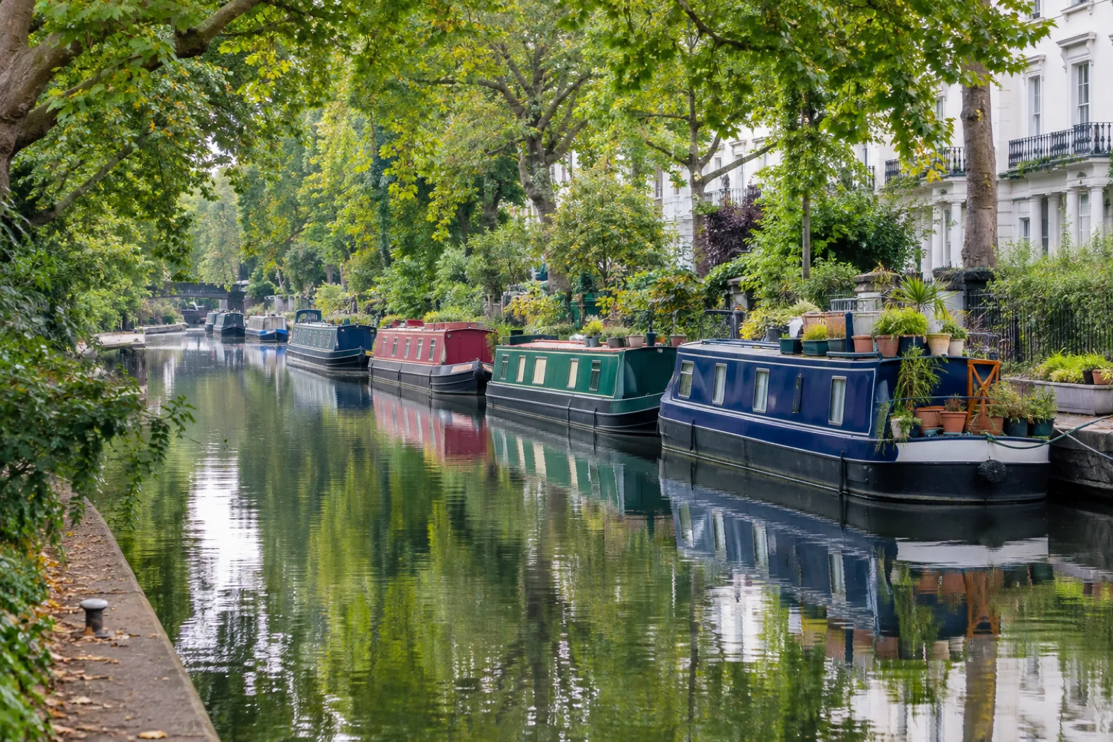 Colourful houseboats moored along a quiet canal in Little Venice, London
